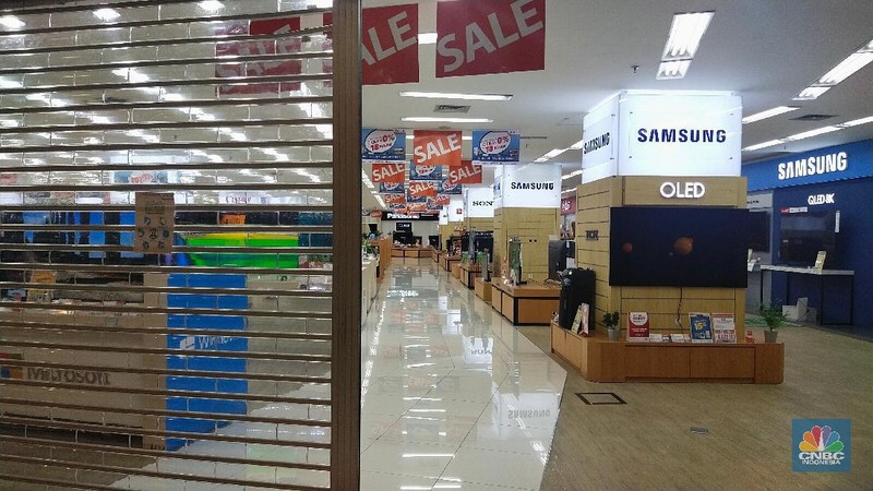 Sejumlah gerai memasang papan pemberitahuan penutupan toko yang berada di salah satu mal di Jakarta, Selasa (29/6/2021). Pemerintah makin memperketat jam operasional pusat perbelanjaan dan restoran. Semula, mal dan restoran diizinkan buka jam 8 malam kini jam operasionalnya harus ditutup hingga jam 5 sore. Pantauan dilokasi ada beberapa store yang menutup tokonya dengan menempelkan papan pemberitahuan. Wahana permainan anak juga ditutup oleh pihak pengelola mal. Pengunjung dimal juga tampak sepi.  (CNBC Indonesia/ Tri Susilo)