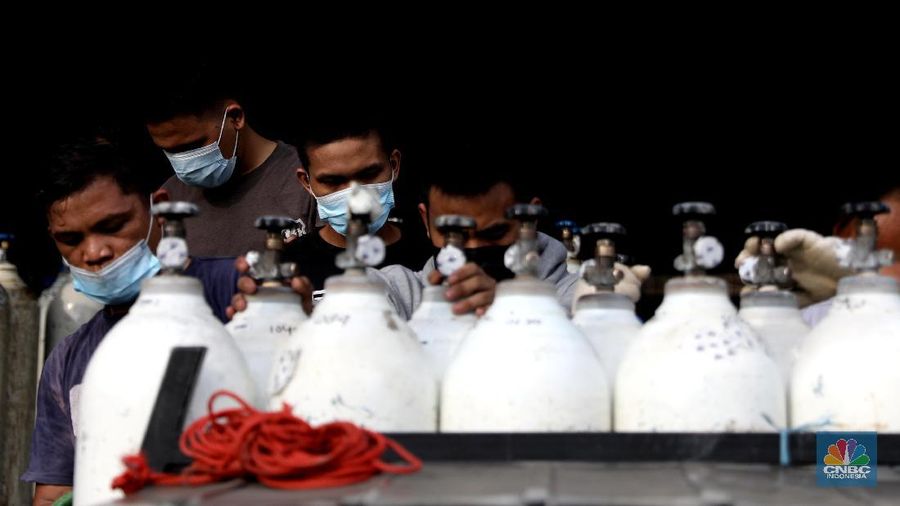 Pekerja menata tabung oksigen di tempat pengisian oksigen PT Aneka Gas Industri, Cakung, Jakarta Timur, Rabu (30/6/2021). Pemprov DKI Jakarta mengerahkan kendaraan dari berbagai Satuan Kerja Perangkat Daerah (SKPD) atau kedinasan di DKI Jakarta untuk membantu mendistribusikan oksigen ke berbagai Rumah Sakit rujukan Covid-19. Hal tersebut dilakukan untuk mempercepat sirkulasi tabung oksigen yang sempat mengalami kelangkaan beberapa hari lalu. Pantauan CNBC Indonesia beberapa truk dari perangkat daerah seperti Dishub DKI hingga SDA ikut mengantri mengambil oksigen. Antrian pengisian dilokasi tersebut juga memakan waktu lama. Salah satu sopir truk mengaku ia mengantri dari jam 7 pagi hingga pukul 15.30 belum juga bisa diangkut. Karena antrian truk yang begitu ramai. Tempat pengisian Oksigen ini melayani hingga 24 jam. (CNBC Indonesia/ Muhammad Sabki)