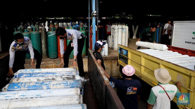 Pekerja menata tabung oksigen di tempat pengisian oksigen PT Aneka Gas Industri, Cakung, Jakarta Timur, Rabu (30/6/2021). Pemprov DKI Jakarta mengerahkan kendaraan dari berbagai Satuan Kerja Perangkat Daerah (SKPD) atau kedinasan di DKI Jakarta untuk membantu mendistribusikan oksigen ke berbagai Rumah Sakit rujukan Covid-19.  Hal tersebut dilakukan untuk mempercepat sirkulasi tabung oksigen yang sempat mengalami kelangkaan beberapa hari lalu. Pantauan CNBC Indonesia beberapa truk dari perangkat daerah seperti Dishub DKI hingga SDA ikut mengantri mengambil oksigen. Antrian pengisian dilokasi tersebut juga memakan waktu lama. Salah satu sopir truk mengaku ia mengantri dari jam 7 pagi hingga pukul 15.30 belum juga bisa diangkut. Karena antrian truk yang begitu ramai. Tempat pengisian Oksigen ini melayani hingga 24 jam.  (CNBC Indonesia/ Muhammad Sabki)
