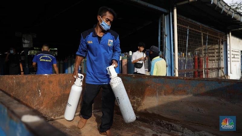 Pekerja menata tabung oksigen di tempat pengisian oksigen PT Aneka Gas Industri, Cakung, Jakarta Timur, Rabu (30/6/2021). Pemprov DKI Jakarta mengerahkan kendaraan dari berbagai Satuan Kerja Perangkat Daerah (SKPD) atau kedinasan di DKI Jakarta untuk membantu mendistribusikan oksigen ke berbagai Rumah Sakit rujukan Covid-19.  Hal tersebut dilakukan untuk mempercepat sirkulasi tabung oksigen yang sempat mengalami kelangkaan beberapa hari lalu. Pantauan CNBC Indonesia beberapa truk dari perangkat daerah seperti Dishub DKI hingga SDA ikut mengantri mengambil oksigen. Antrian pengisian dilokasi tersebut juga memakan waktu lama. Salah satu sopir truk mengaku ia mengantri dari jam 7 pagi hingga pukul 15.30 belum juga bisa diangkut. Karena antrian truk yang begitu ramai. Tempat pengisian Oksigen ini melayani hingga 24 jam.  (CNBC Indonesia/ Muhammad Sabki)