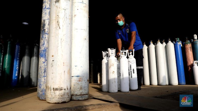 Pekerja menata tabung oksigen di tempat pengisian oksigen PT Aneka Gas Industri, Cakung, Jakarta Timur, Rabu (30/6/2021). Pemprov DKI Jakarta mengerahkan kendaraan dari berbagai Satuan Kerja Perangkat Daerah (SKPD) atau kedinasan di DKI Jakarta untuk membantu mendistribusikan oksigen ke berbagai Rumah Sakit rujukan Covid-19.  Hal tersebut dilakukan untuk mempercepat sirkulasi tabung oksigen yang sempat mengalami kelangkaan beberapa hari lalu. Pantauan CNBC Indonesia beberapa truk dari perangkat daerah seperti Dishub DKI hingga SDA ikut mengantri mengambil oksigen. Antrian pengisian dilokasi tersebut juga memakan waktu lama. Salah satu sopir truk mengaku ia mengantri dari jam 7 pagi hingga pukul 15.30 belum juga bisa diangkut. Karena antrian truk yang begitu ramai. Tempat pengisian Oksigen ini melayani hingga 24 jam.  (CNBC Indonesia/ Muhammad Sabki)
