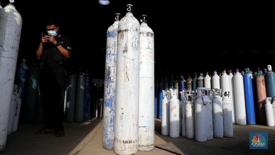 Pekerja menata tabung oksigen di tempat pengisian oksigen PT Aneka Gas Industri, Cakung, Jakarta Timur, Rabu (30/6/2021). Pemprov DKI Jakarta mengerahkan kendaraan dari berbagai Satuan Kerja Perangkat Daerah (SKPD) atau kedinasan di DKI Jakarta untuk membantu mendistribusikan oksigen ke berbagai Rumah Sakit rujukan Covid-19.  Hal tersebut dilakukan untuk mempercepat sirkulasi tabung oksigen yang sempat mengalami kelangkaan beberapa hari lalu. Pantauan CNBC Indonesia beberapa truk dari perangkat daerah seperti Dishub DKI hingga SDA ikut mengantri mengambil oksigen. Antrian pengisian dilokasi tersebut juga memakan waktu lama. Salah satu sopir truk mengaku ia mengantri dari jam 7 pagi hingga pukul 15.30 belum juga bisa diangkut. Karena antrian truk yang begitu ramai. Tempat pengisian Oksigen ini melayani hingga 24 jam.  (CNBC Indonesia/ Muhammad Sabki)