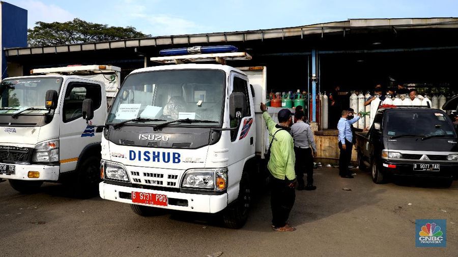 Pekerja menata tabung oksigen di tempat pengisian oksigen PT Aneka Gas Industri, Cakung, Jakarta Timur, Rabu (30/6/2021). Pemprov DKI Jakarta mengerahkan kendaraan dari berbagai Satuan Kerja Perangkat Daerah (SKPD) atau kedinasan di DKI Jakarta untuk membantu mendistribusikan oksigen ke berbagai Rumah Sakit rujukan Covid-19.  Hal tersebut dilakukan untuk mempercepat sirkulasi tabung oksigen yang sempat mengalami kelangkaan beberapa hari lalu. Pantauan CNBC Indonesia beberapa truk dari perangkat daerah seperti Dishub DKI hingga SDA ikut mengantri mengambil oksigen. Antrian pengisian dilokasi tersebut juga memakan waktu lama. Salah satu sopir truk mengaku ia mengantri dari jam 7 pagi hingga pukul 15.30 belum juga bisa diangkut. Karena antrian truk yang begitu ramai. Tempat pengisian Oksigen ini melayani hingga 24 jam.  (CNBC Indonesia/ Muhammad Sabki)