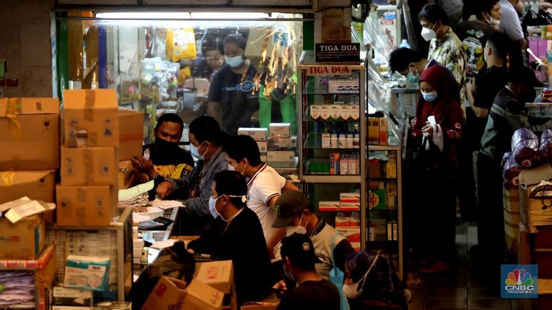 Pedagang melayani pengunjung di Pasar Pramuka, Jakarta, Rabu (30/6/2021). Tingginya kasus positif Covid-19 di Jakarta membuat penjualan alat kesehatan, obat, dan vitamin di Pasar Pramuka meningkat hingga 100 persen. Salah satu pedagang di Pasar Pramuka mengatakan untuk obat-obatan vitamin paling banyak di konsumsi. Iya mengatakan vitamin C yang banyak dibeli karena dianggap mampu meningkatkan imunitas tubuh di masa pandemi. Meski banyaknya permintaan, para pedagang pasar tidak menaikkan harga. Harga jual vitamin yang berkisar mulai dari Rp30 ribu hingga di atas Rp100 ribu. (CNBC Indonesia/ Muhammad Sabki)