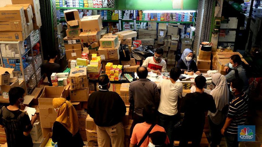 Pedagang melayani pengunjung di Pasar Pramuka, Jakarta, Rabu (30/6/2021). Tingginya kasus positif Covid-19 di Jakarta membuat penjualan alat kesehatan, obat, dan vitamin di Pasar Pramuka meningkat hingga 100 persen. Salah satu pedagang di Pasar Pramuka mengatakan untuk obat-obatan vitamin paling banyak di konsumsi. Iya mengatakan vitamin C yang banyak dibeli karena dianggap mampu meningkatkan imunitas tubuh di masa pandemi. Meski banyaknya permintaan, para pedagang pasar tidak menaikkan harga. Harga jual vitamin yang berkisar mulai dari Rp30 ribu hingga di atas Rp100 ribu. (CNBC Indonesia/ Muhammad Sabki)