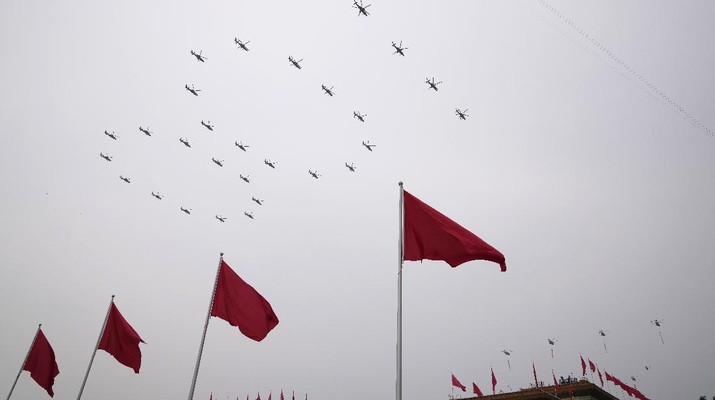 Helicopters fly over Chinese flags at Tiananmen Square in the formation of 