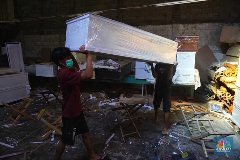 Pekerja menyelesaikan pembuatan peti untuk jenazah Covid-19 di Batu Ceper, Kota Tangerang, Banten, Jumat (2/7/2021). Produksi peti jenazah ditempat tersebut sehari bisa memproduksi 300 hingga 450 peti dengan sistem kerja tiga shift. Menurut Frans Henrik (46) Kenaikan pembuatan peti jenazah naik 100 persen, untuk harga per unit mulai dari Rp. 1,2 juta hingga Rp.1,5 juta