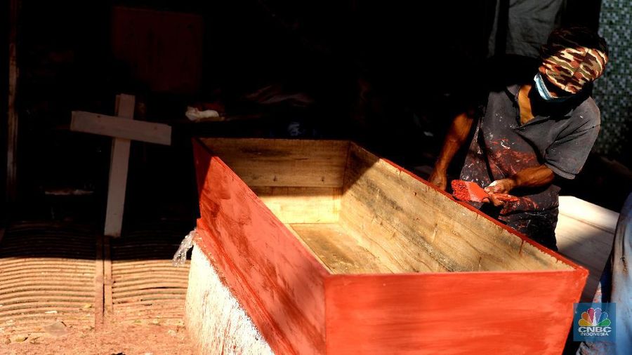 Pekerja menyelesaikan pesanan peti jenazah di Kawasan TPU Pondok Kelapa, Jakarta, Jumat, (2/7). Lonjakan angka kematian karena virus Covid-19 membuat pesanan peti jenazah mengalami peningkatan pesanan. Dalam rentang waktu seminggu ini, pihak Sahabat Duka telah membuat hampir sebanyak 250 peti jenazah.  CV Sahabat Duka yang berbasis di Tempat Pemakaman Umum (TPU) Pondok Kelapa, Jakarta Timur bak kejatuhan durian runtuh. Pesanan peti mati setiap harinya terus bertambah. 