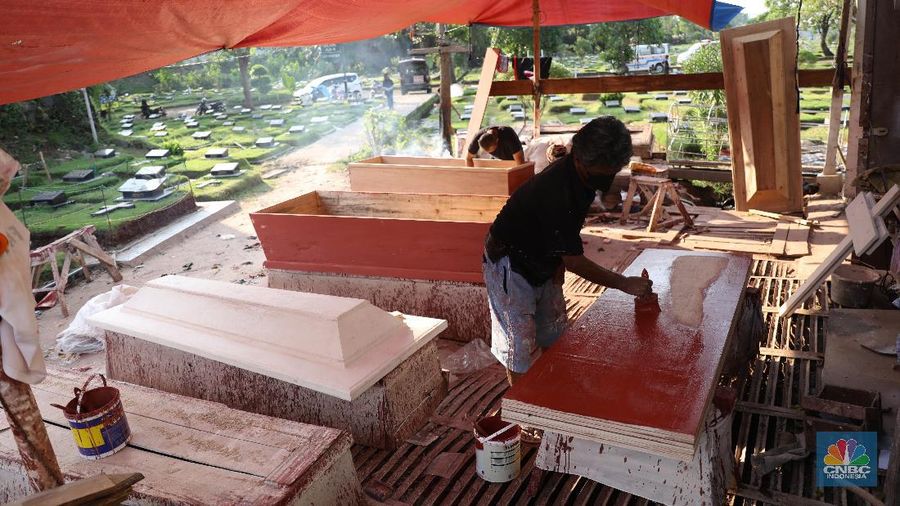 Pekerja menyelesaikan pesanan peti jenazah di Kawasan TPU Pondok Kelapa, Jakarta, Jumat, (2/7). Lonjakan angka kematian karena virus Covid-19 membuat pesanan peti jenazah mengalami peningkatan pesanan. Dalam rentang waktu seminggu ini, pihak Sahabat Duka telah membuat hampir sebanyak 250 peti jenazah. CV Sahabat Duka yang berbasis di Tempat Pemakaman Umum (TPU) Pondok Kelapa, Jakarta Timur bak kejatuhan durian runtuh. Pesanan peti mati setiap harinya terus bertambah.