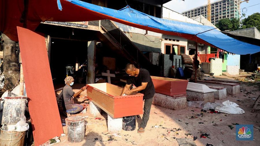 Pekerja menyelesaikan pesanan peti jenazah di Kawasan TPU Pondok Kelapa, Jakarta, Jumat, (2/7). Lonjakan angka kematian karena virus Covid-19 membuat pesanan peti jenazah mengalami peningkatan pesanan. Dalam rentang waktu seminggu ini, pihak Sahabat Duka telah membuat hampir sebanyak 250 peti jenazah.  CV Sahabat Duka yang berbasis di Tempat Pemakaman Umum (TPU) Pondok Kelapa, Jakarta Timur bak kejatuhan durian runtuh. Pesanan peti mati setiap harinya terus bertambah. 
