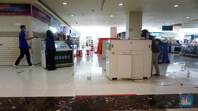 Sejumlah karyawan toko mulai menutup tokonya di mal kawasan Jakarta, Jumat (2/7/2021). Bisnis usat perbelanjaan semakin tertekan karena dilarang beroperasi besok selama PPKM Darurat 3 - 20 Juli 2021, imbasnya tenaga kerja mal dan penyewa tenenttenent sudah pasti dirumahkan. Salah satu karyawan toko mengatakan 