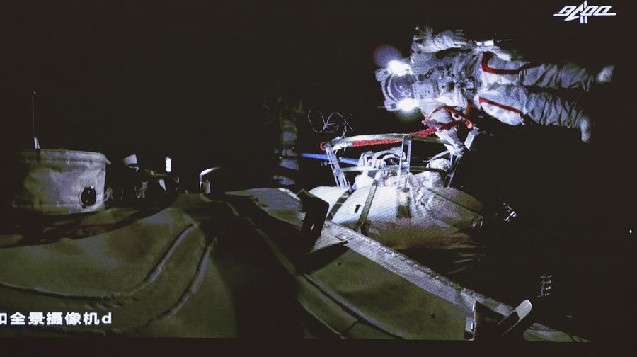 This photo released by Xinhua News Agency shows a screen at Beijing Aerospace Control Center showing astronaut Liu Boming stepping out of core module of the China's new space station in space on Sunday, July 4, 2021. Two astronauts made the first space walk on Sunday outside China's new orbital station to work on setting up a 15-meter (50-foot) long robotic arm. (Jin Liwang/Xinhua via AP)
