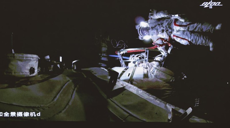 This photo released by Xinhua News Agency shows a screen at Beijing Aerospace Control Center showing astronaut Liu Boming stepping out of core module of the China's new space station in space on Sunday, July 4, 2021. Two astronauts made the first space walk on Sunday outside China's new orbital station to work on setting up a 15-meter (50-foot) long robotic arm. (Jin Liwang/Xinhua via AP)