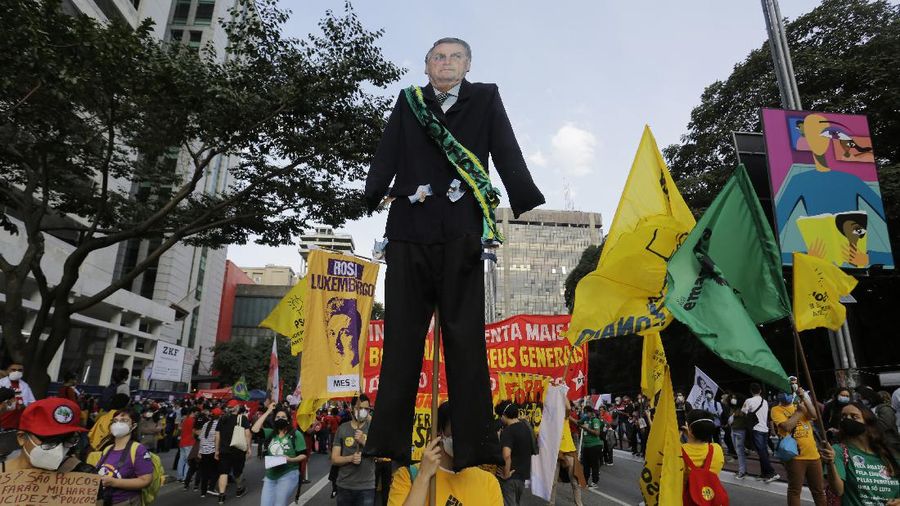 A giant cutout of Brazilian President Jair Bolsonaro towers over demonstrators marching along Paulista Avenue demanding Bolsonaro resign, in Sao Paulo, Brazil, Saturday, July 3, 2021. Activists called for nationwide demonstrations against Bolsonaro, gathering protestors to demand his impeachment amid allegations of potential corruption in the Health Ministry’s purchase of COVID-19 vaccines. (AP Photo/Nelson Antoine)