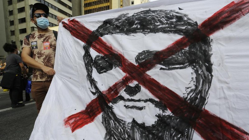 A giant cutout of Brazilian President Jair Bolsonaro towers over demonstrators marching along Paulista Avenue demanding Bolsonaro resign, in Sao Paulo, Brazil, Saturday, July 3, 2021. Activists called for nationwide demonstrations against Bolsonaro, gathering protestors to demand his impeachment amid allegations of potential corruption in the Health Ministry’s purchase of COVID-19 vaccines. (AP Photo/Nelson Antoine)