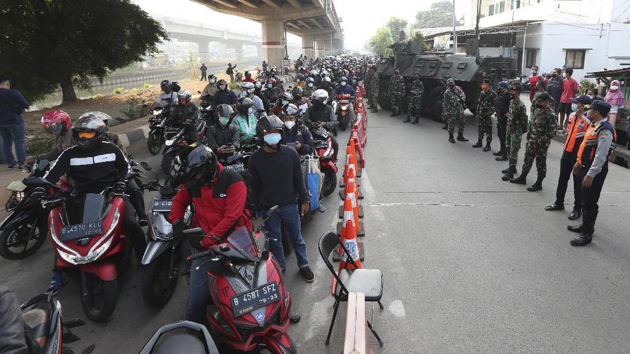 Aparat berjaga pos penyekatan PPKM Darurat di Kalimalang, Jakarta, Senin (5/7/2021). (AP/Achmad Ibrahim)