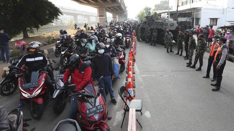 Aparat berjaga pos penyekatan PPKM Darurat di Kalimalang, Jakarta, Senin (5/7/2021). (AP/Achmad Ibrahim)