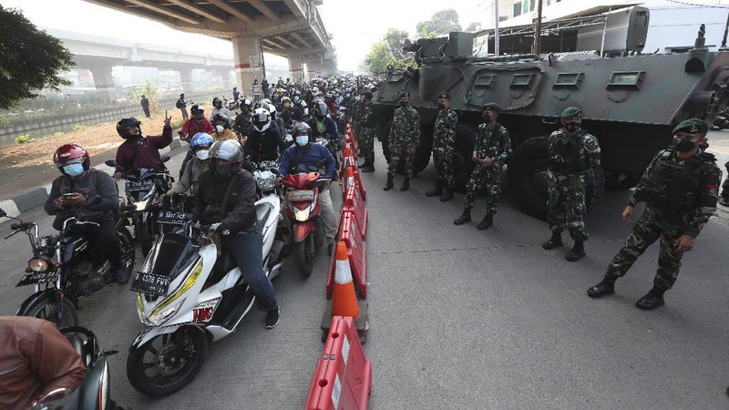 Aparat berjaga pos penyekatan PPKM Darurat di Kalimalang, Jakarta, Senin (5/7/2021). (AP/Achmad Ibrahim)