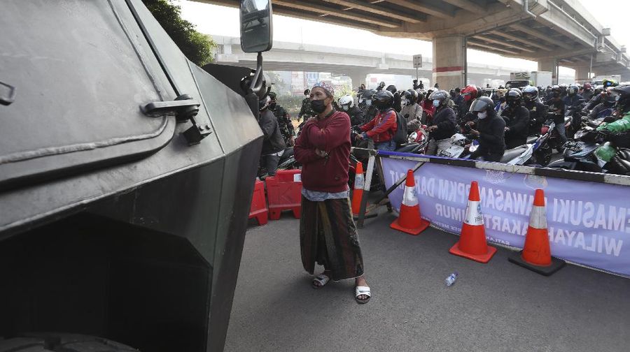 Aparat berjaga pos penyekatan PPKM Darurat di Kalimalang, Jakarta, Senin (5/7/2021). (AP/Achmad Ibrahim)