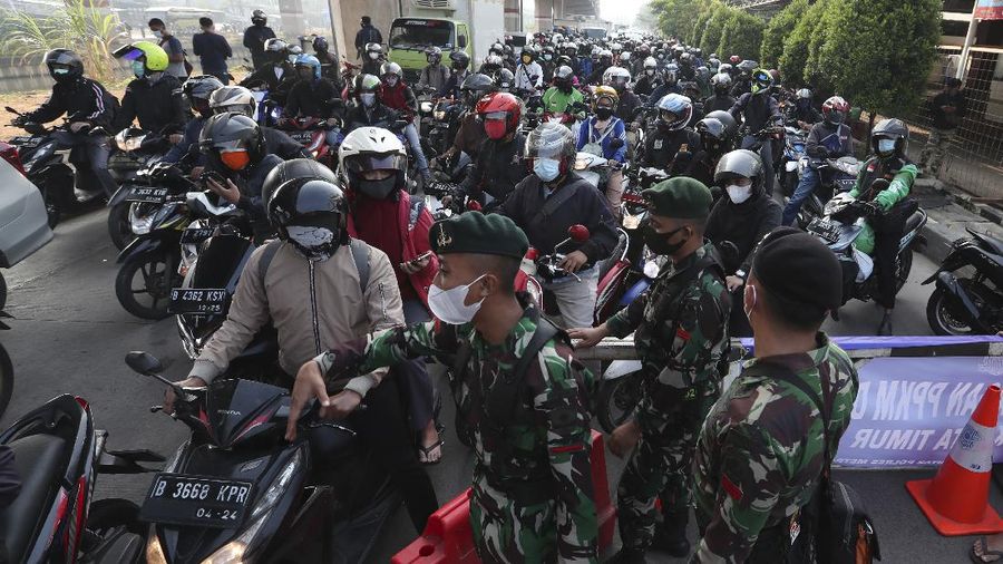 Aparat berjaga pos penyekatan PPKM Darurat di Kalimalang, Jakarta, Senin (5/7/2021). (AP/Achmad Ibrahim)