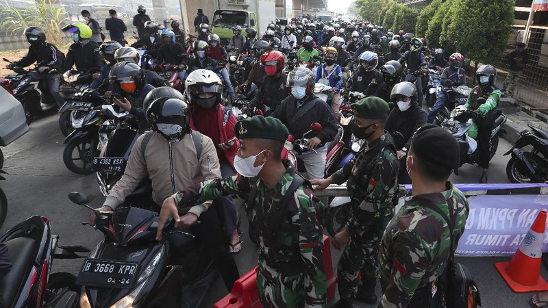Aparat berjaga pos penyekatan PPKM Darurat di Kalimalang, Jakarta, Senin (5/7/2021). (AP/Achmad Ibrahim)