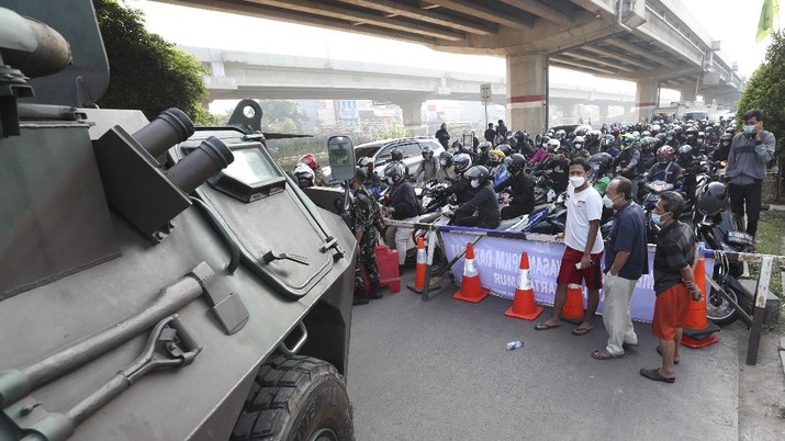 Aparat berjaga pos penyekatan PPKM Darurat di Kalimalang, Jakarta, Senin (5/7/2021). (AP/Achmad Ibrahim)