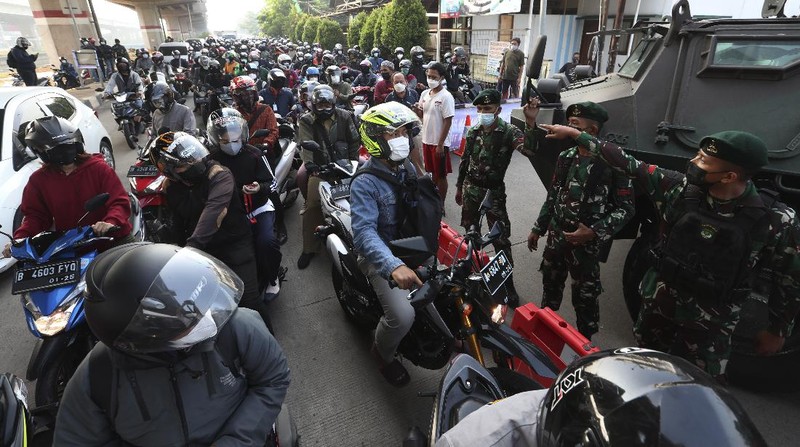 Aparat berjaga pos penyekatan PPKM Darurat di Kalimalang, Jakarta, Senin (5/7/2021). (AP/Achmad Ibrahim)