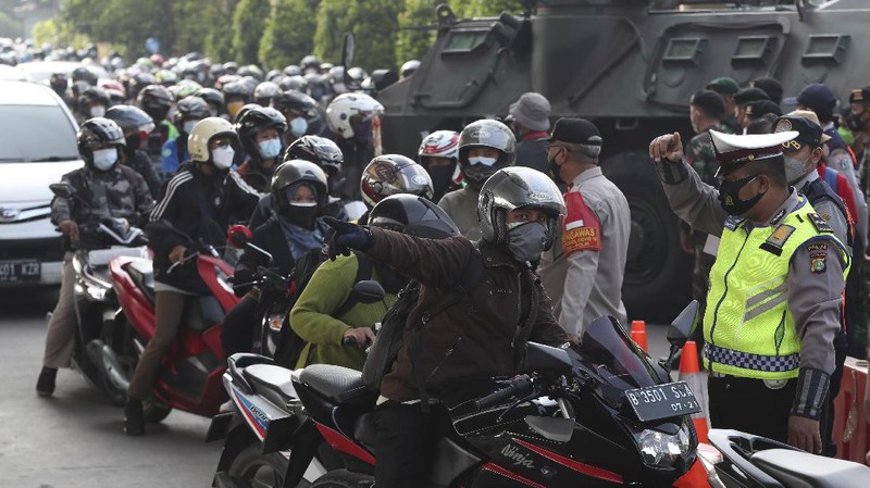Aparat berjaga pos penyekatan PPKM Darurat di Kalimalang, Jakarta, Senin (5/7/2021). (AP/Achmad Ibrahim)
