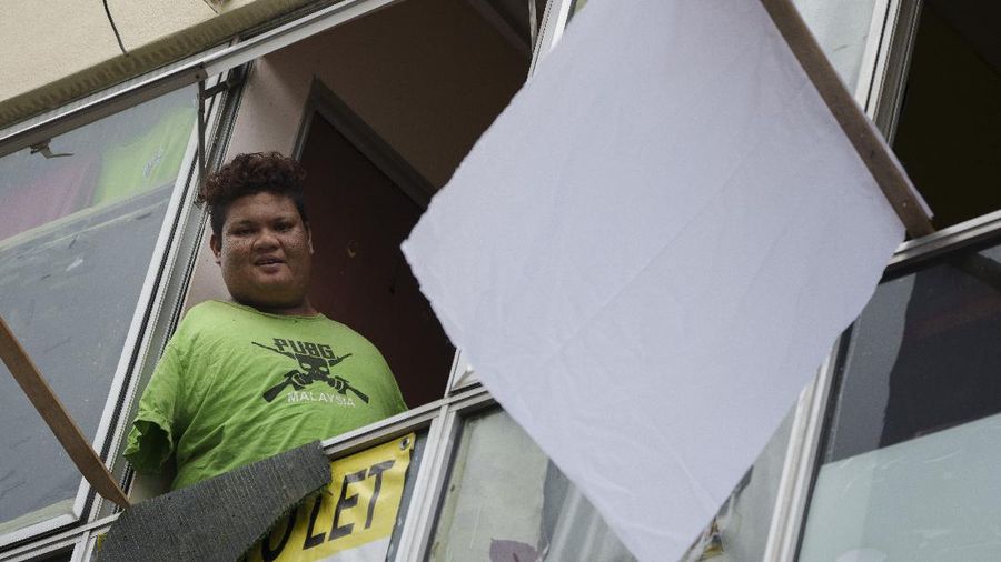 Warga Malaysia menggencarkan kampanye kibar bendera putih untuk saling membantu menghadapi masa sulit, terutama karena lockdown demi meredam Covid-19. (AP/Vincent Thian)