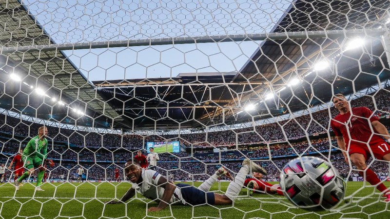 Denmark's Mikkel Damsgaard, left, scores his side's opening goal from a free kick during the Euro 2020 soccer semifinal match between England and Denmark at Wembley stadium in London, Wednesday, July 7, 2021. (Laurence Griffiths/Pool Photo via AP)