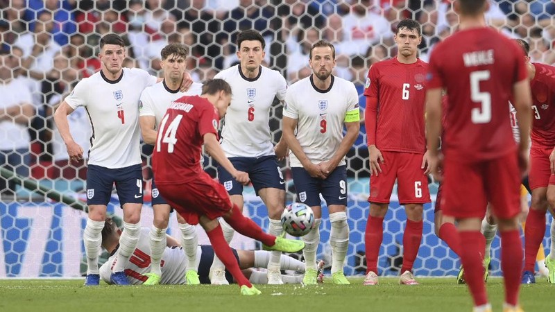 Denmark's Mikkel Damsgaard, left, scores his side's opening goal from a free kick during the Euro 2020 soccer semifinal match between England and Denmark at Wembley stadium in London, Wednesday, July 7, 2021. (Laurence Griffiths/Pool Photo via AP)
