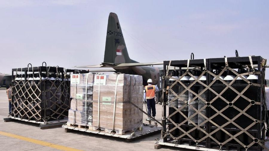 In this photo released by Indonesian Armed Forces, a military personnel uses a forklift to unload relief goods from a Singaporean Air Force cargo plane at Halim Perdanakusuma Airbase in Jakarta, Indonesia, Friday, July 9, 2021. The world's fourth most populous country is running out of oxygen as it endures a devastating wave of coronavirus cases and the government is seeking emergency supplies from other countries, including Singapore and China. (Indonesian Armed Forces via AP)