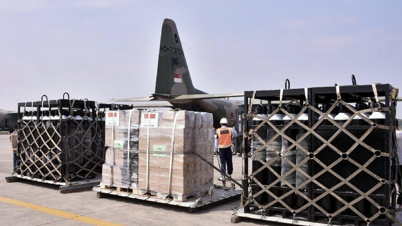 In this photo released by Indonesian Armed Forces, a military personnel uses a forklift to unload relief goods from a Singaporean Air Force cargo plane at Halim Perdanakusuma Airbase in Jakarta, Indonesia, Friday, July 9, 2021. The world's fourth most populous country is running out of oxygen as it endures a devastating wave of coronavirus cases and the government is seeking emergency supplies from other countries, including Singapore and China. (Indonesian Armed Forces via AP)