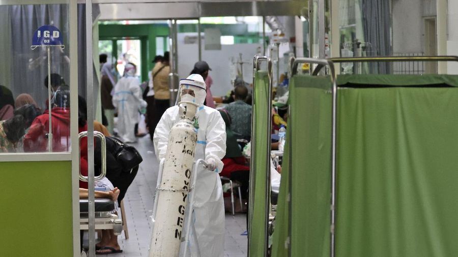 A paramedic pushes an oxygen tank at the emergency ward of an overcrowded hospital amid COVID-19 cases, in Surabaya, East Java, Indonesia, Friday, July 9, 2021. The world's fourth most populous country is running out of oxygen as it endures a devastating wave of coronavirus cases and the government is seeking emergency supplies from other countries, including Singapore and China. (AP Photo/Trisnadi)