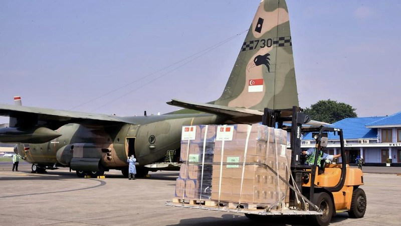In this photo released by Indonesian Armed Forces, a military personnel uses a forklift to unload relief goods from a Singaporean Air Force cargo plane at Halim Perdanakusuma Airbase in Jakarta, Indonesia, Friday, July 9, 2021. The world's fourth most populous country is running out of oxygen as it endures a devastating wave of coronavirus cases and the government is seeking emergency supplies from other countries, including Singapore and China. (Indonesian Armed Forces via AP)