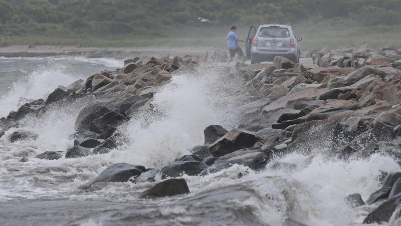 A pedestrian uses an umbrella to shield himself during a downpour from Tropical Storm Elsa, Friday, July 9, 2021, in Portland, Maine. Elsa is the earliest fifth-named storm on record, said Brian McNoldy, a hurricane researcher at the University of Miami. (AP Photo/Robert F. Bukaty)