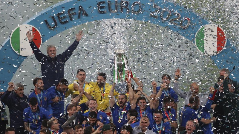 Italy's team celebrates with the trophy on the podium after winning the Euro 2020 soccer championship final between England and Italy at Wembley stadium in London, Sunday, July 11, 2021. (Michael Regan/Pool via AP)