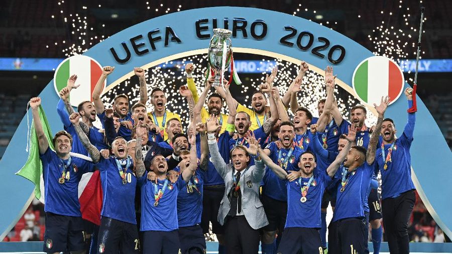 Italy's team celebrates with the trophy on the podium after winning the Euro 2020 soccer championship final between England and Italy at Wembley stadium in London, Sunday, July 11, 2021. (Michael Regan/Pool via AP)