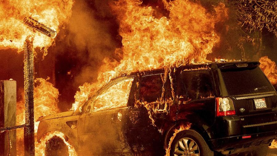 Flames consume a vehicle as the Sugar Fire, part of the Beckwourth Complex Fire, tears through Doyle, Calif., Saturday, July 10, 2021. Pushed by heavy winds amid a heat wave, the fire came out of the hills and destroyed multiple residences in central Doyle. (AP Photo/Noah Berger)