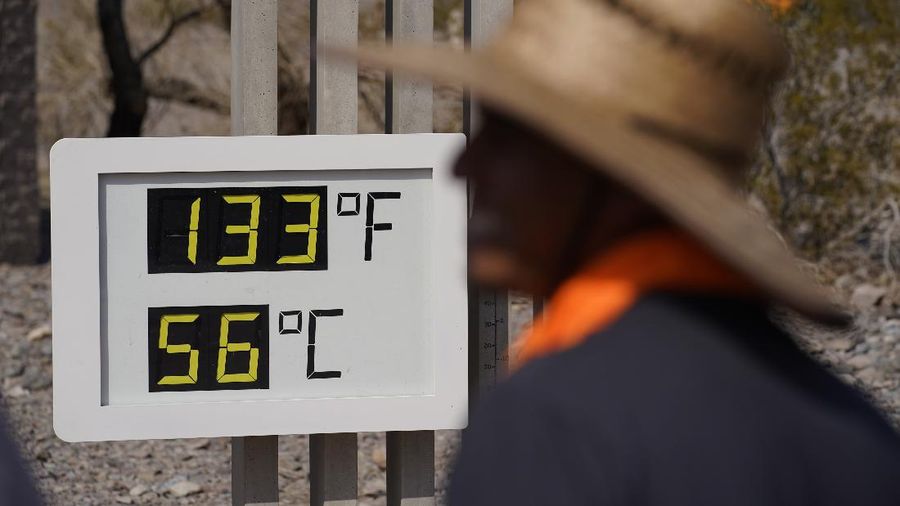 People visit a thermometer Sunday, July 11, 2021, in Death Valley National Park, Calif. Death Valley in southeastern California's Mojave Desert reached 128 degrees Fahrenheit (53 Celsius) on Saturday, according to the National Weather Service's reading at Furnace Creek. The high temperature was actually lower than the previous day, when the location reached 130 F (54 C). (AP Photo/John Locher)