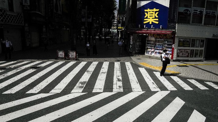 Tokyo Olympics A man waiting to cross the street is seen from a shuttle bus ahead of the 2020 Summer Olympics, Monday, July 12, 2021, in Tokyo. (AP Photo/Jae C. Hong)