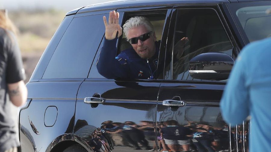 Virgin Galactic founder Richard Branson waves good bye while heading to board the rocket plane that will fly him to space from Spaceport America near Truth or Consequences, New Mexico, Sunday, July 11, 2021. (AP Photo/Andres Leighton)