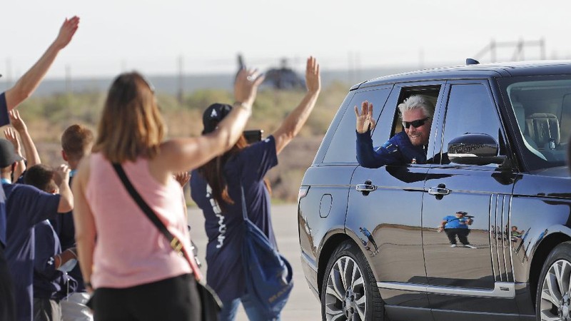 Virgin Galactic founder Richard Branson, left, sprays champagne to his crew members while celebrating their flight to space from Spaceport America near Truth or Consequences, N.M., Sunday, July 11, 2021. (AP Photo/Andres Leighton)
