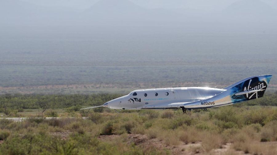 Virgin Galactic founder Richard Branson, left, sprays champagne to his crew members while celebrating their flight to space from Spaceport America near Truth or Consequences, N.M., Sunday, July 11, 2021. (AP Photo/Andres Leighton)