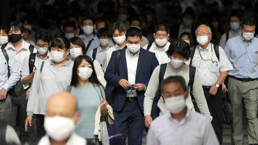 Commuters wearing face masks walk in a passageway during a rush hour at Shinagawa Station Monday, July 12, 2021, in Tokyo. Japan declared the fourth state of emergency for Tokyo from Monday until Aug. 22. (AP Photo/Eugene Hoshiko)