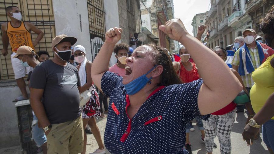 A woman shouts pro-government slogans as anti-government protesters march in Havana, Cuba, Sunday, July 11, 2021. Hundreds of demonstrators took to the streets in several cities in Cuba to protest against ongoing food shortages and high prices of foodstuffs. (AP Photo/Ismael Francisco)