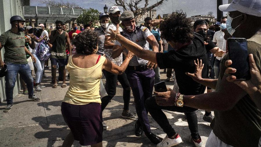 Backers of the government march in Havana, Cuba, Sunday, July 11, 2021. Hundreds of supporters of the government took to the streets while hundreds more protested against ongoing food shortages and high prices of foodstuffs. (AP Photo/Eliana Aponte)