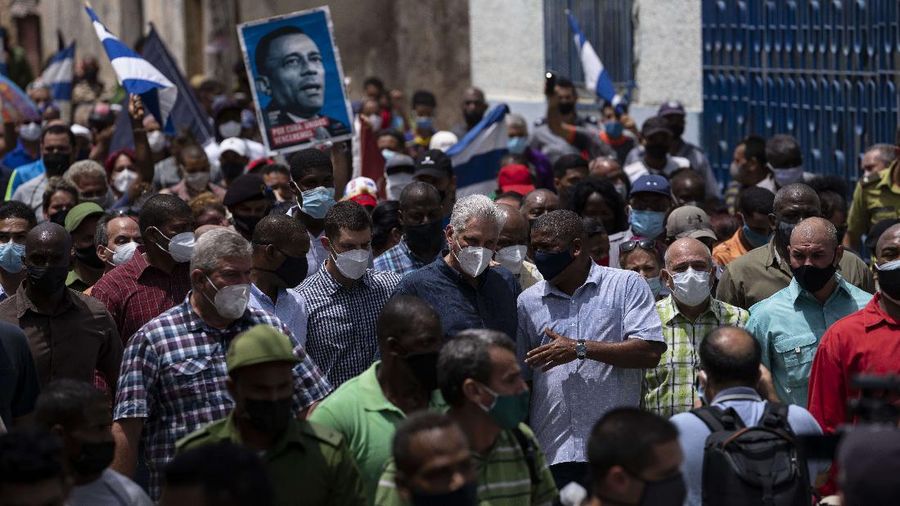 Cuba's President Miguel Diaz Canel walks with his followers after an anti-government protest in San Antonio de los Banos, Cuba, Sunday July 11, 2021. Hundreds of demonstrators went out to the streets in several cities in Cuba to protest against ongoing food shortages and high prices of foodstuffs, amid the new coronavirus crisis. (AP Photo/Ramon Espinosa)