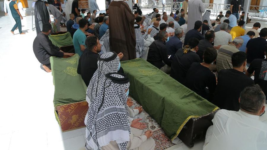 People gather outside a COVID-19 hospital in Nasiriyah, Iraq, early Tuesday, July 13, 2021. A catastrophic blaze erupted at the coronavirus hospital ward. It was the second time a large fire killed coronavirus patients in an Iraqi hospital this year. (AP Photo)