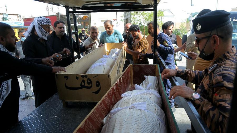 People gather outside a COVID-19 hospital in Nasiriyah, Iraq, early Tuesday, July 13, 2021. A catastrophic blaze erupted at the coronavirus hospital ward. It was the second time a large fire killed coronavirus patients in an Iraqi hospital this year. (AP Photo)
